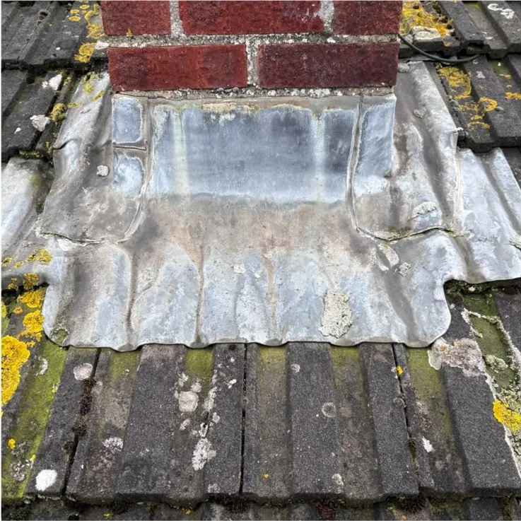 Before: split, patched lead around a chimney