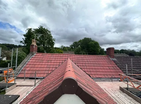 Red ridge and hip tiles bedded on a new roof
