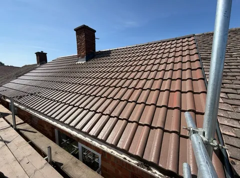 New interlocking tile roof finished around a brick chimney