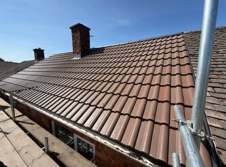 New interlocking tile roof finished around a brick chimney