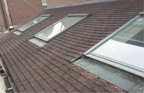 Old roof with three roof windows before work